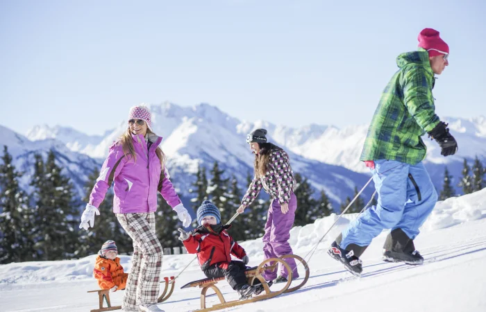 Family tobogganing fun in winter