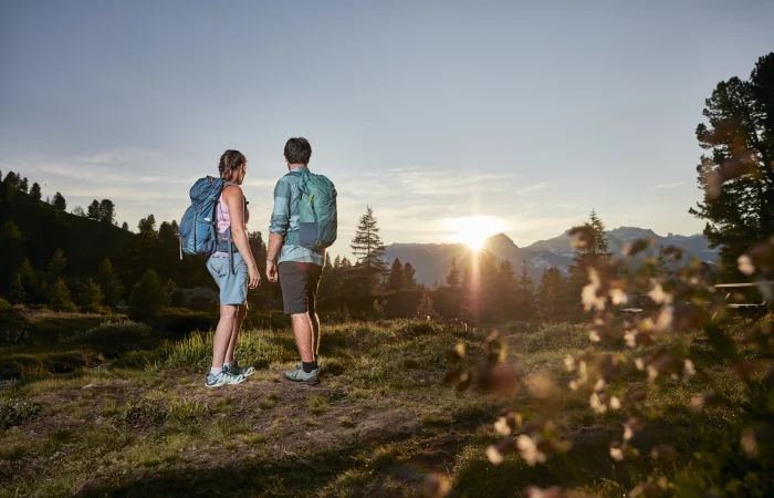 Pärchen steht auf dem Berg vor Sonnenuntergang