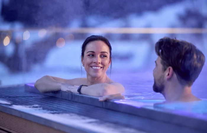 Couple relaxing in a warm pool during a romantic evening atmosphere