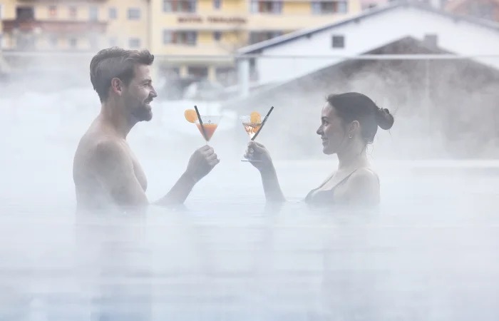 A couple toasting drinks in the pool