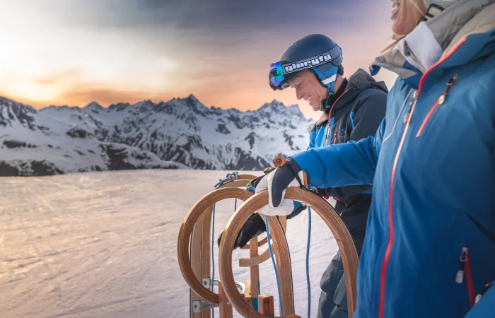 Personen mit Rodeln auf der Piste